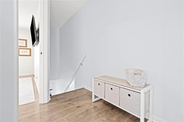 interior space with light wood-style flooring and an upstairs landing