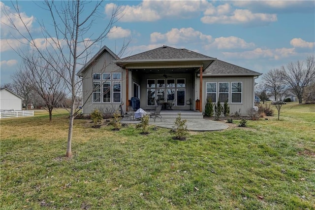 rear view of property with a lawn and a patio