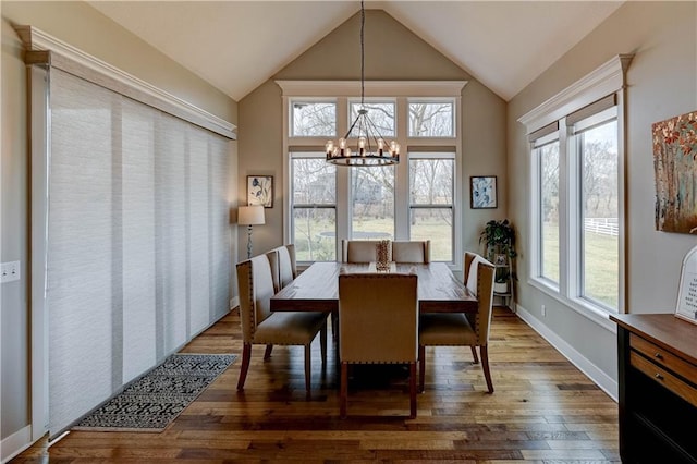 dining space featuring lofted ceiling, dark hardwood / wood-style floors, and a chandelier