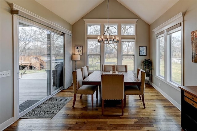 dining room featuring lofted ceiling, dark hardwood / wood-style floors, and a notable chandelier