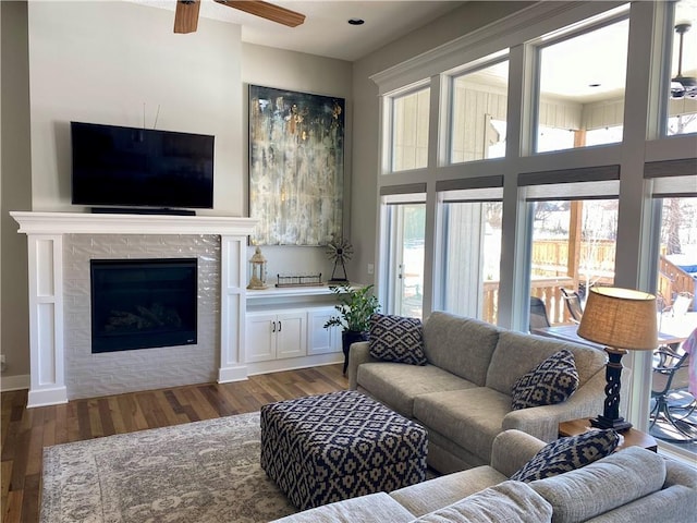 living room with a towering ceiling, a fireplace, dark hardwood / wood-style flooring, and a wealth of natural light