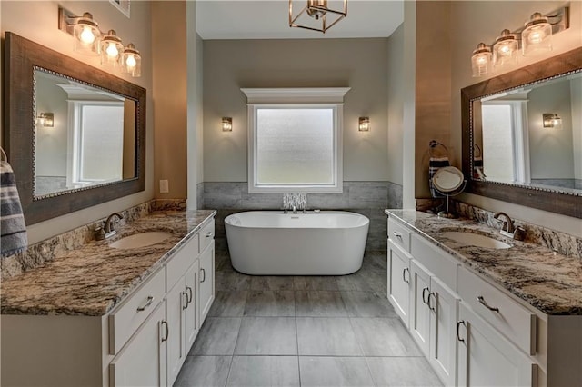 bathroom featuring vanity, tile walls, tile patterned floors, and a bathtub