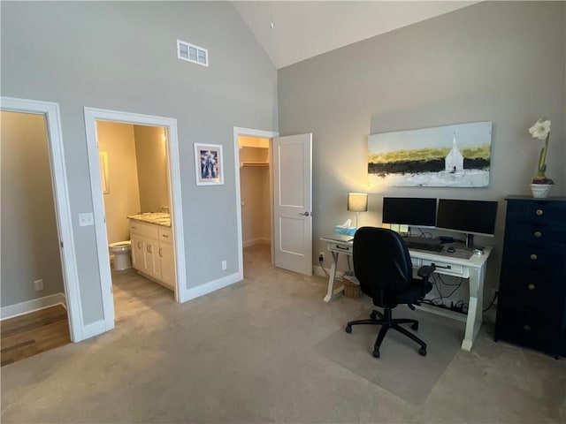 carpeted office space with high vaulted ceiling