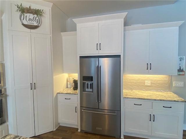 17895 168th St, Basehor, KS 66007 - kitchen with high end fridge, tasteful backsplash, white cabinetry, and light stone countertops