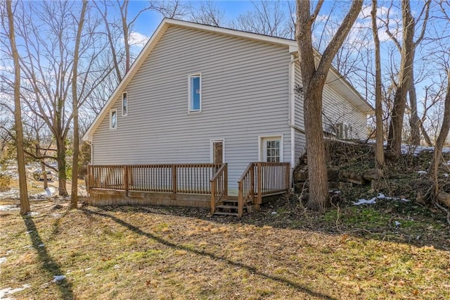 view of side of home with a deck and a yard