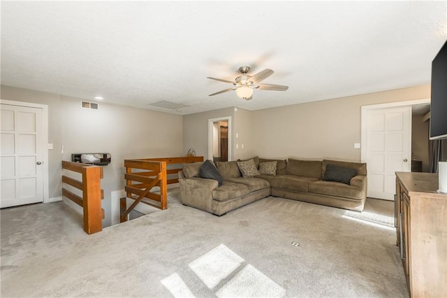 living area with light colored carpet, visible vents, and ceiling fan