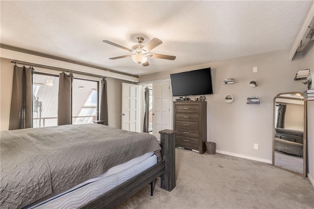 bedroom with light carpet, ceiling fan, a textured ceiling, and baseboards