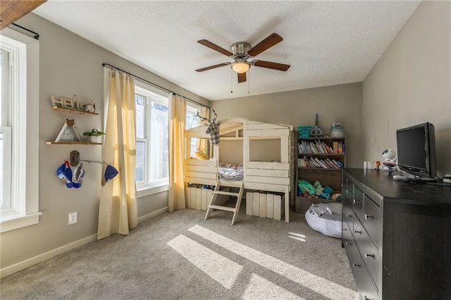 bedroom with a ceiling fan, a textured ceiling, baseboards, and carpet flooring