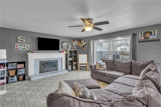 living room featuring ceiling fan, light colored carpet, a textured ceiling, and a fireplace