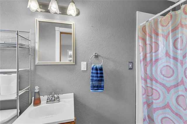 bathroom with toilet, vanity, and a shower with curtain