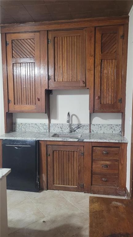 kitchen with light stone counters, sink, and dishwasher