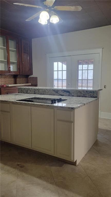 kitchen with black electric cooktop, plenty of natural light, ceiling fan, decorative backsplash, and cream cabinetry