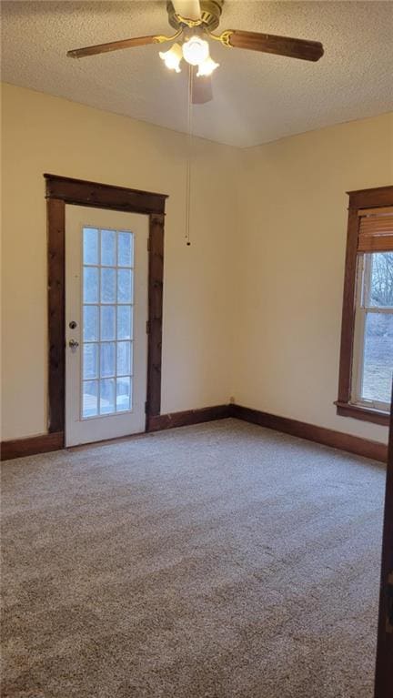 carpeted empty room featuring ceiling fan and a textured ceiling