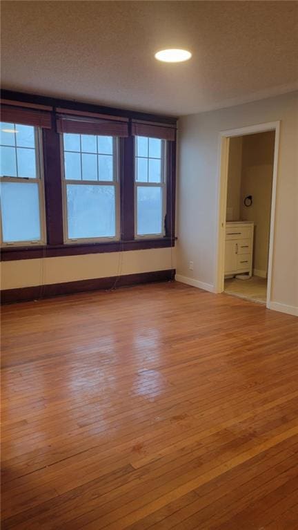 empty room featuring a textured ceiling and light wood-type flooring