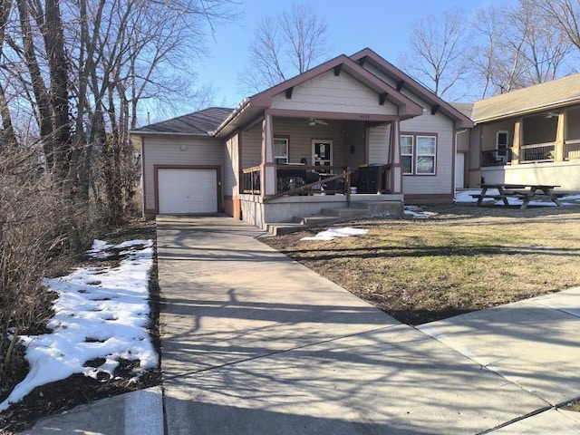 view of front of property featuring a porch, a garage, and a lawn