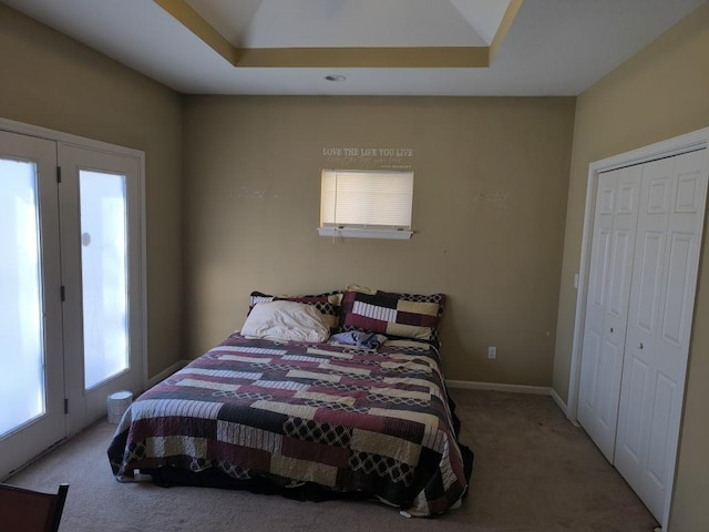 bedroom featuring a closet, a raised ceiling, and carpet