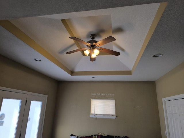 details featuring a tray ceiling and ceiling fan