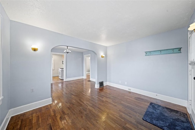 unfurnished room featuring baseboards, arched walkways, and dark wood-type flooring