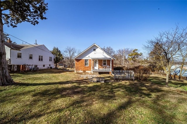 back of house with a yard and brick siding