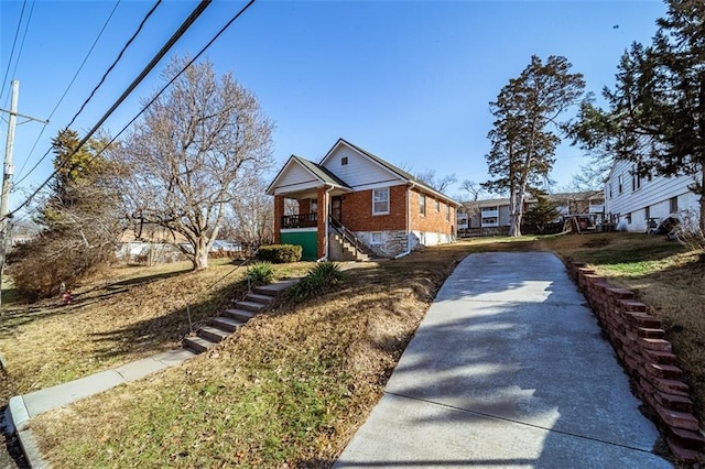 view of front of property with covered porch, brick siding, and stairway