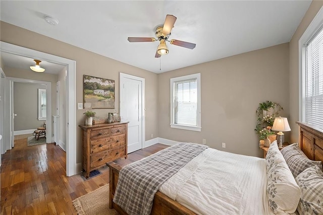 bedroom with ceiling fan, dark wood finished floors, and baseboards