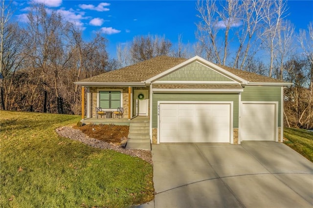 view of front of property featuring a garage, covered porch, and a front lawn