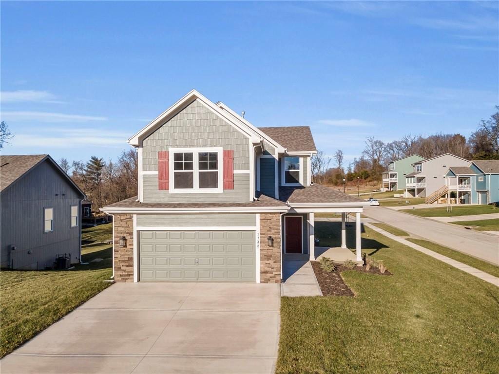 view of front of property featuring a garage, central AC, and a front yard