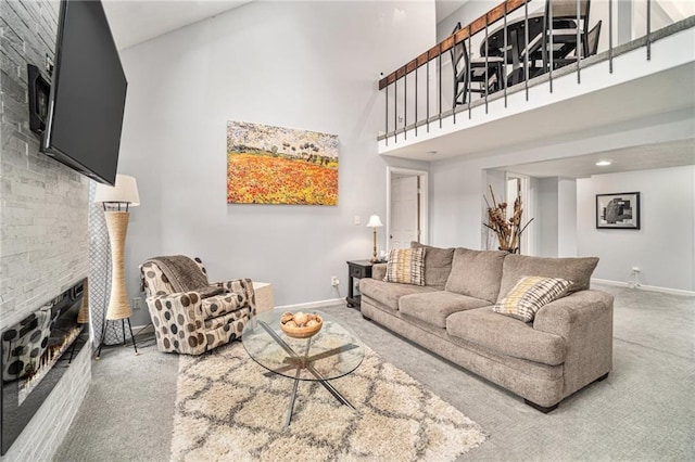 living room featuring carpet flooring, a fireplace, and a high ceiling