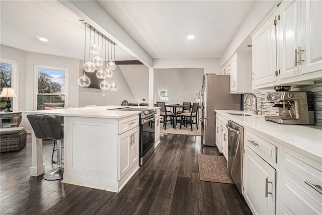 kitchen featuring sink, white cabinetry, decorative light fixtures, dark hardwood / wood-style flooring, and stainless steel appliances