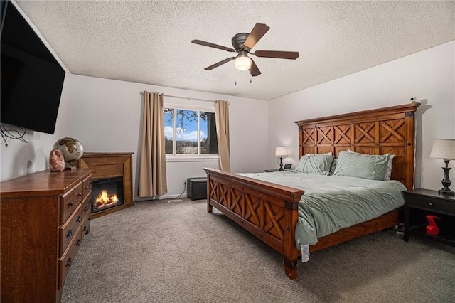 bedroom with carpet, a textured ceiling, and ceiling fan