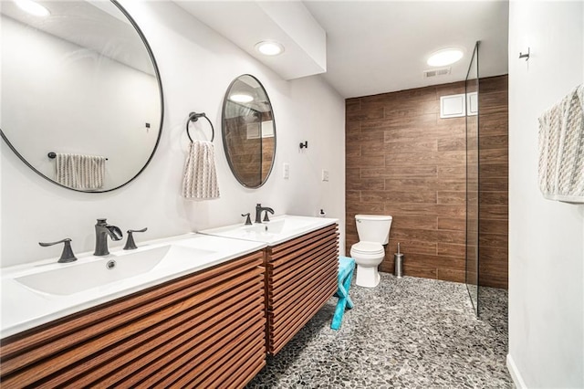 bathroom with tiled shower, tile patterned floors, vanity, and toilet