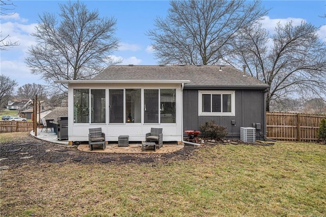 rear view of house with a sunroom, a lawn, central AC unit, and a patio area