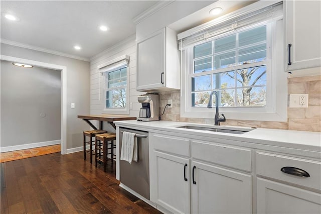 kitchen with crown molding, dark wood-type flooring, dishwasher, decorative backsplash, and a sink