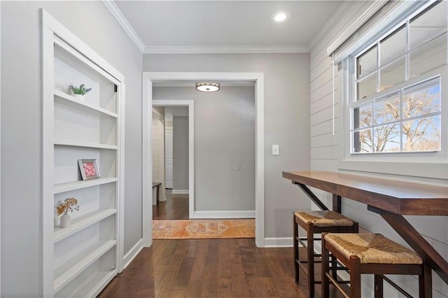 hall with crown molding, baseboards, dark wood-type flooring, and built in shelves