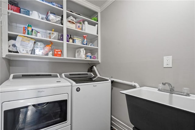 clothes washing area with laundry area, washer and clothes dryer, and a sink