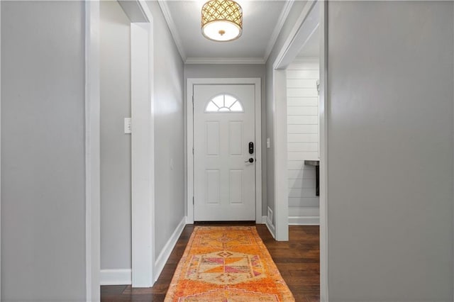 doorway to outside featuring baseboards, dark wood-type flooring, and crown molding