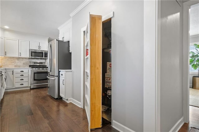 kitchen featuring stainless steel appliances, tasteful backsplash, dark wood-type flooring, and white cabinetry