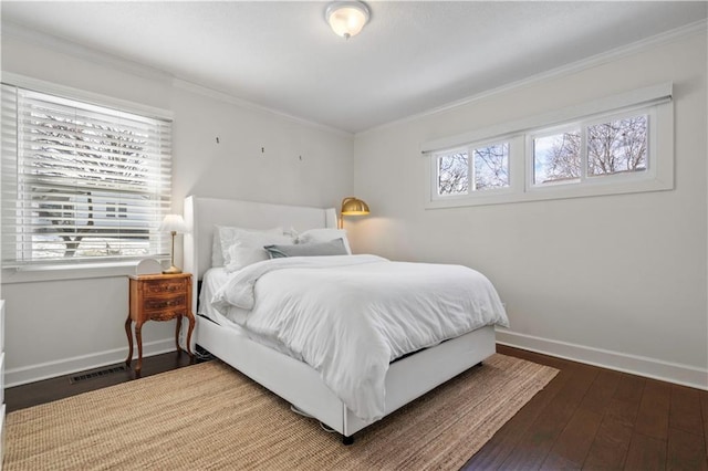 bedroom featuring visible vents, crown molding, baseboards, and hardwood / wood-style floors