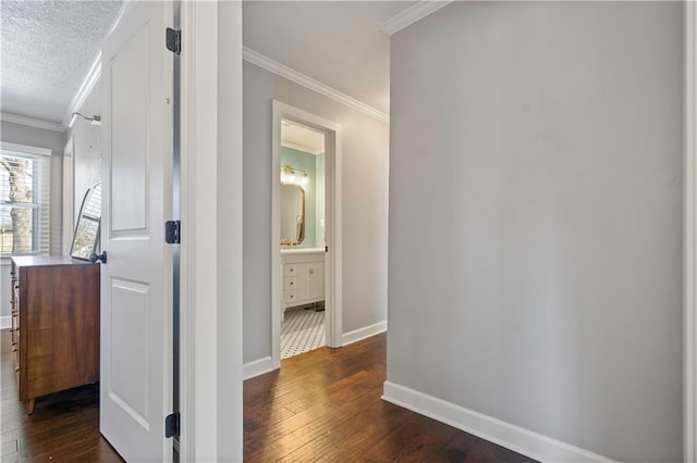 hallway with crown molding, baseboards, dark wood-type flooring, and a textured ceiling