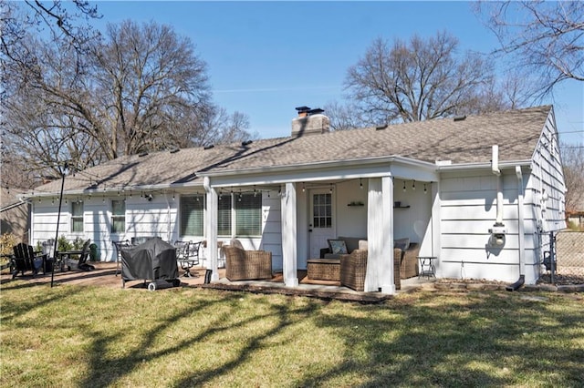 back of house with a yard, a patio area, and a chimney