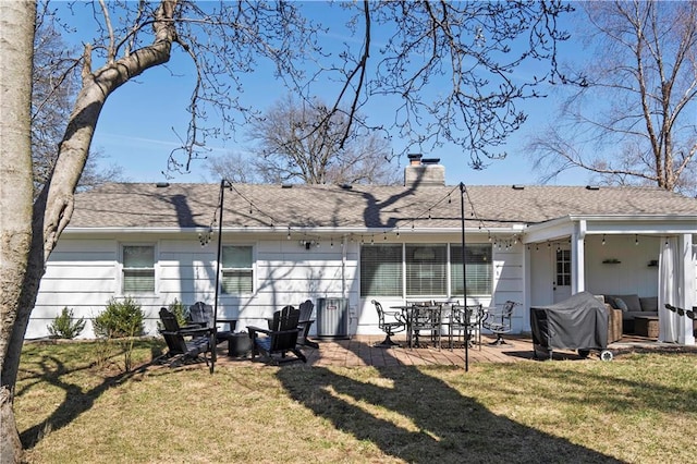 rear view of house with an outdoor living space, roof with shingles, a chimney, a yard, and a patio