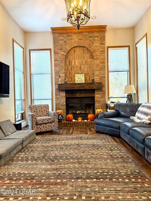 living room with an inviting chandelier and a brick fireplace