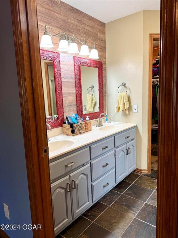 bathroom featuring vanity and wooden walls