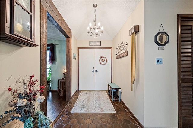 foyer entrance featuring lofted ceiling, dark hardwood / wood-style flooring, a textured ceiling, and an inviting chandelier