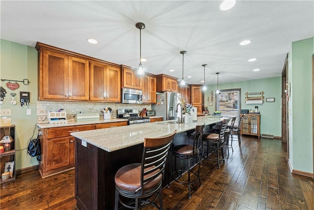 kitchen with a large island, decorative light fixtures, a breakfast bar area, and stainless steel appliances