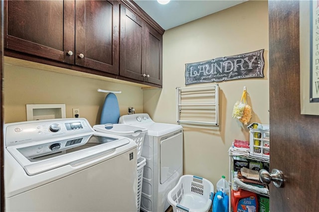 clothes washing area with cabinets and washing machine and dryer