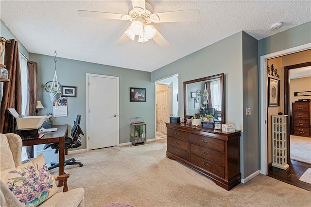 carpeted office space with ceiling fan and a textured ceiling