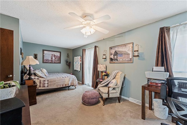 bedroom with light carpet, ceiling fan, and a textured ceiling