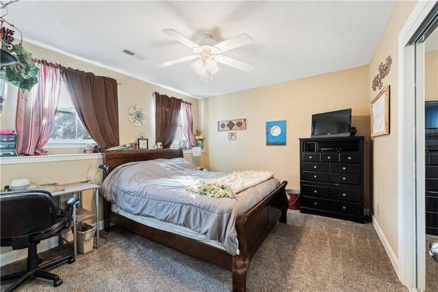 carpeted bedroom featuring ceiling fan and a textured ceiling