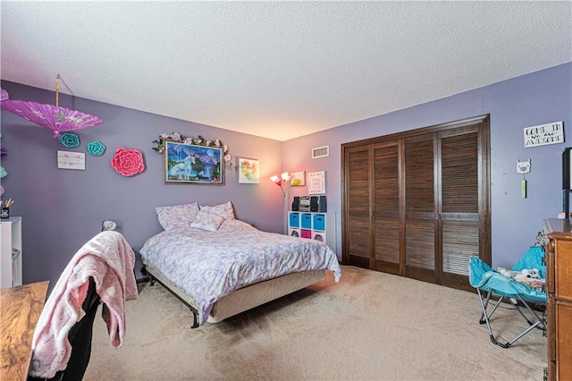 bedroom with light carpet, a textured ceiling, and a closet